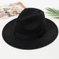 Chapeau Fedora marron posé sur une table en bois