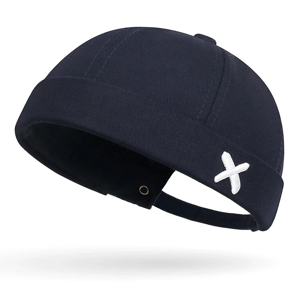 Gros plan sur la broderie en forme de croix du bonnet Docker