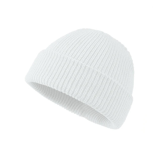 Bonnet en maille épaisse, posé sur une table en bois