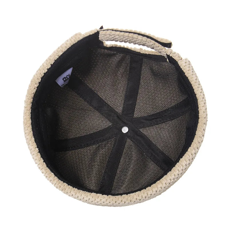 Bonnet tricoté bleu marine posé sur une table en bois