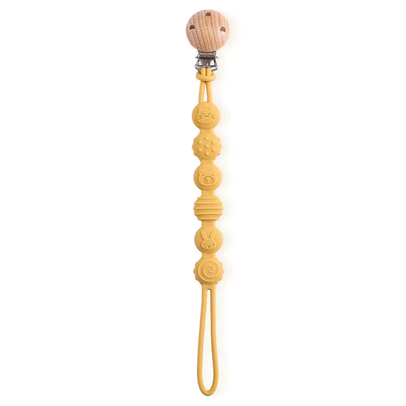 Attache sucette en bois et silicone sur un fond clair