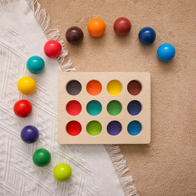 Main d'enfant tenant une boule en bois, apprentissage des couleurs