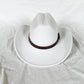 Chapeau cowboy accroché à une branche, ambiance naturelle