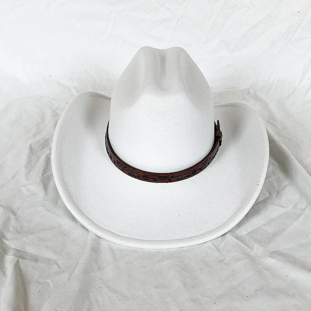 Chapeau cowboy accroché à une branche, ambiance naturelle
