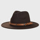Chapeau Fedora en laine sur une chaise, avec un fond de mur en briques