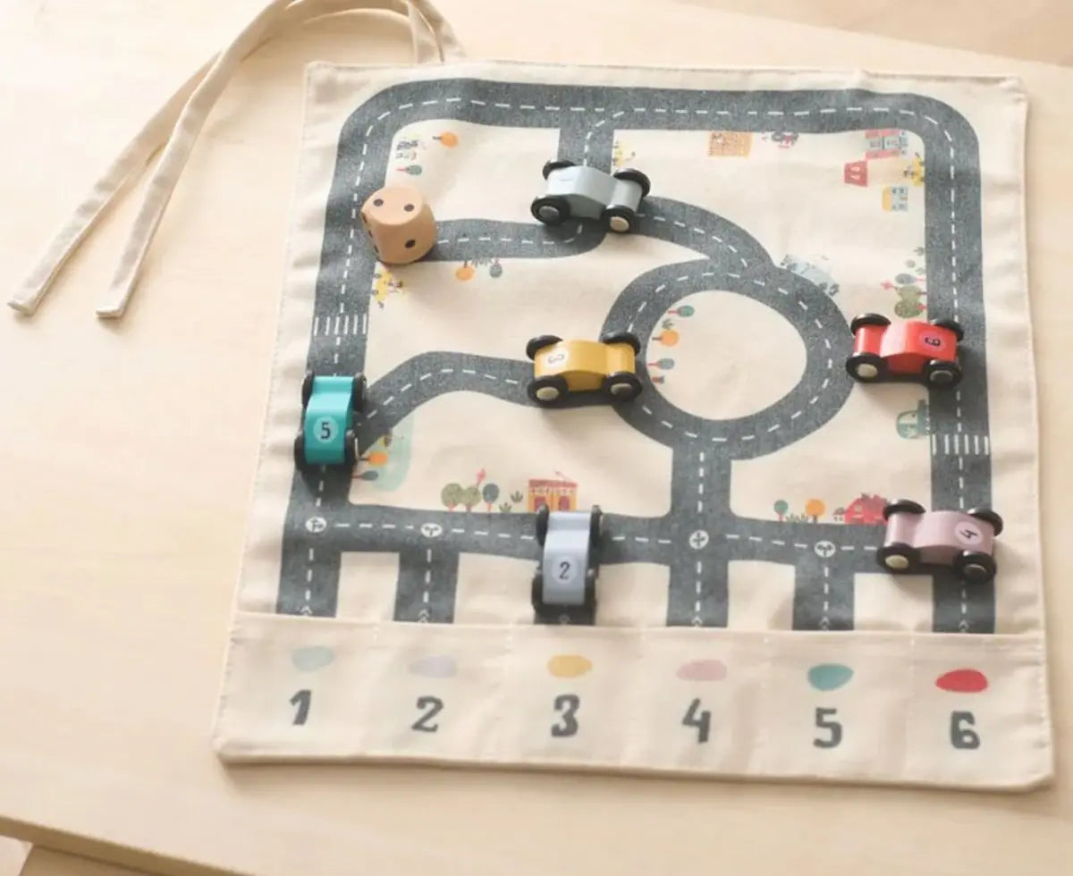 Enfant jouant avec voitures en bois sur tapis de route