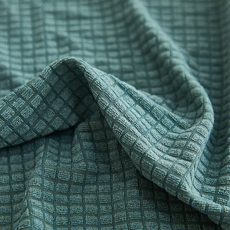 Démonstration de l'élasticité de la housse verte sur un coussin