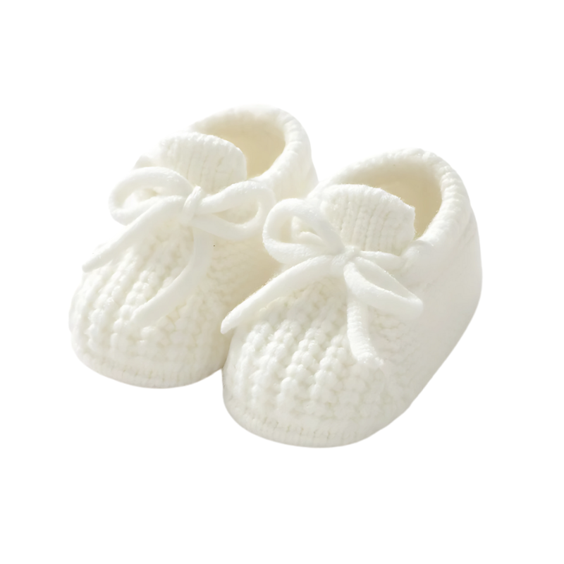 Chaussons bébé tricotés blancs, texture douce visible