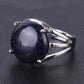 Main portant une bague avec pierre noire sertie