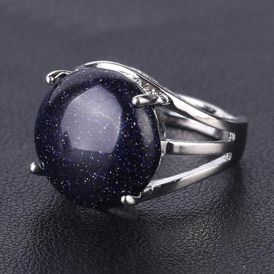 Main portant une bague avec pierre noire sertie