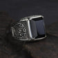 Bague en argent et obsidienne noire posée sur une surface blanche