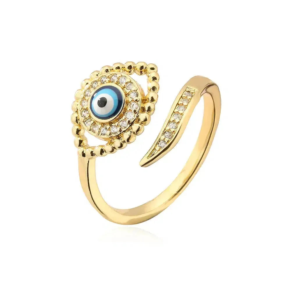 Bague œil bleu dorée, mise en scène sur un fond blanc