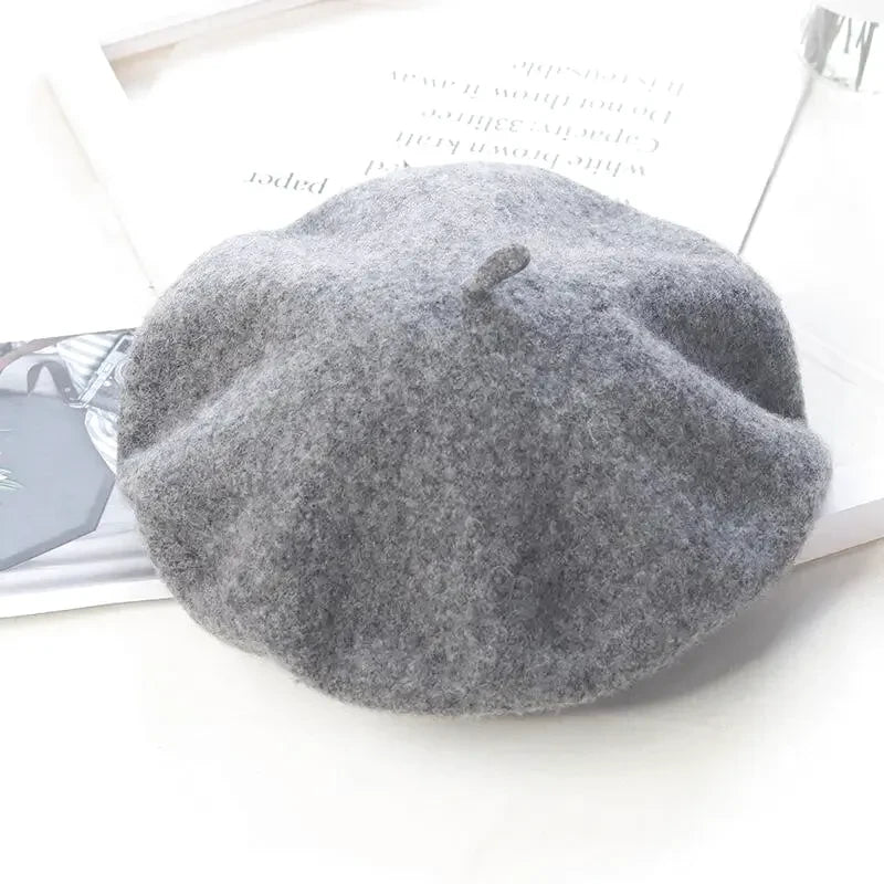 Béret basque gris posé sur une surface en bois