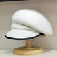 Béret en laine blanc ajustable posé sur une surface