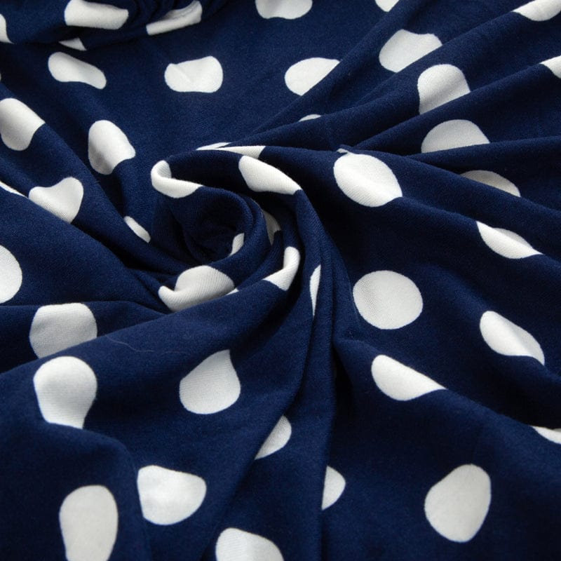 Vue latérale d'une housse de coussin bleue à pois