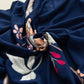 Vue latérale d'une housse de coussin bleue à fleurs