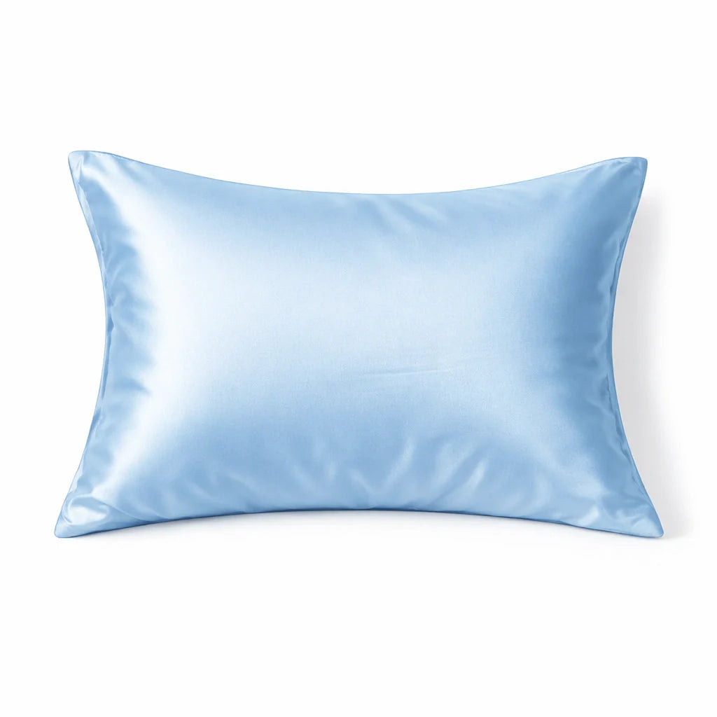 Taie d'oreiller en soie bleu ciel sur un lit blanc