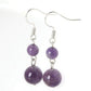 Boucles d'oreilles en améthyste sur fond blanc, perles rondes