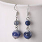 Boucles d'oreilles améthyste posées sur une surface claire