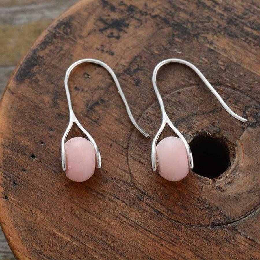 Détail des pierres opale rose sur boucles d'oreilles étrier