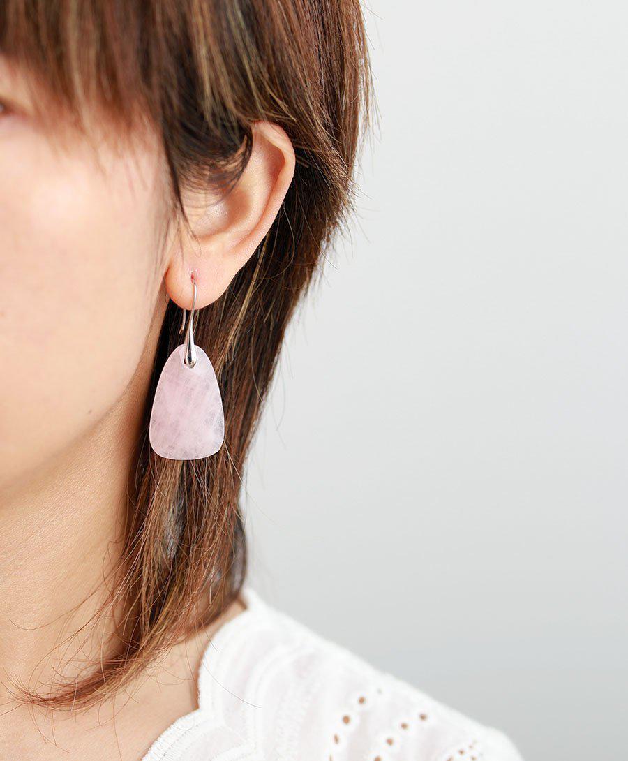 Gros plan sur le quartz rose des boucles d'oreilles