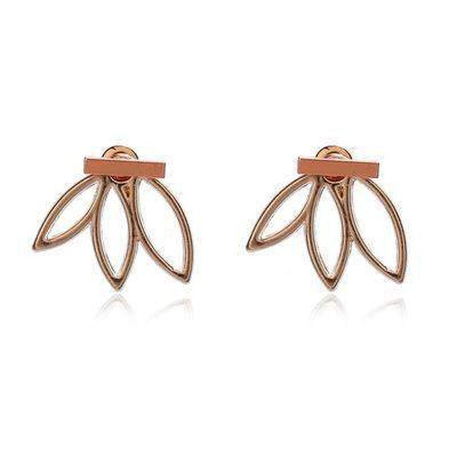 Boucles d'oreilles lotus posées sur une surface en bois