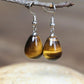 Boucles d'oreilles goutte en Œil de tigre sur fond blanc