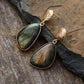 Boucles d'oreilles pendantes en labradorite sur fond neutre