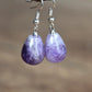 Boucles d'oreilles pendantes en améthyste sur fond blanc