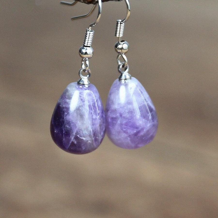 Boucles d'oreilles pendantes en améthyste sur fond blanc