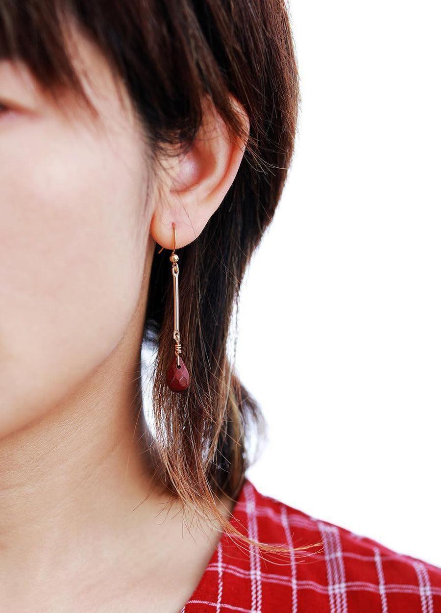 Boucles d'oreilles pendantes en jaspe rouge facetté sur fond blanc