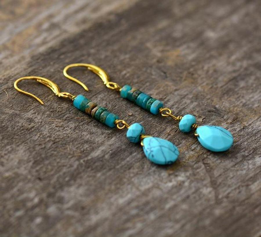 Boucles d'oreilles pendantes en turquoise sur fond blanc