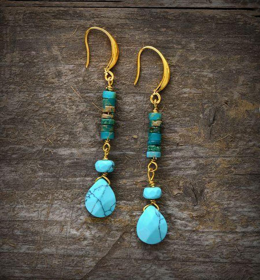 Vue rapprochée des boucles d'oreilles turquoise et dorées