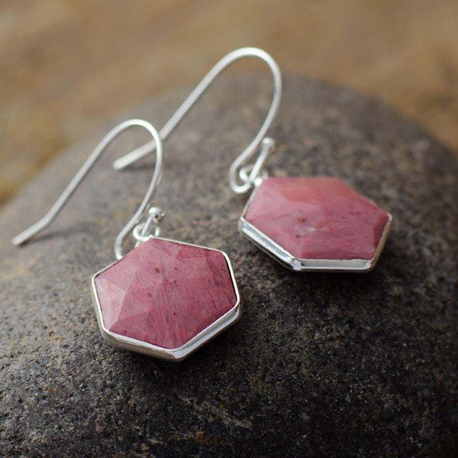 Boucles d'oreilles pendantes en rhodonite sur fond blanc