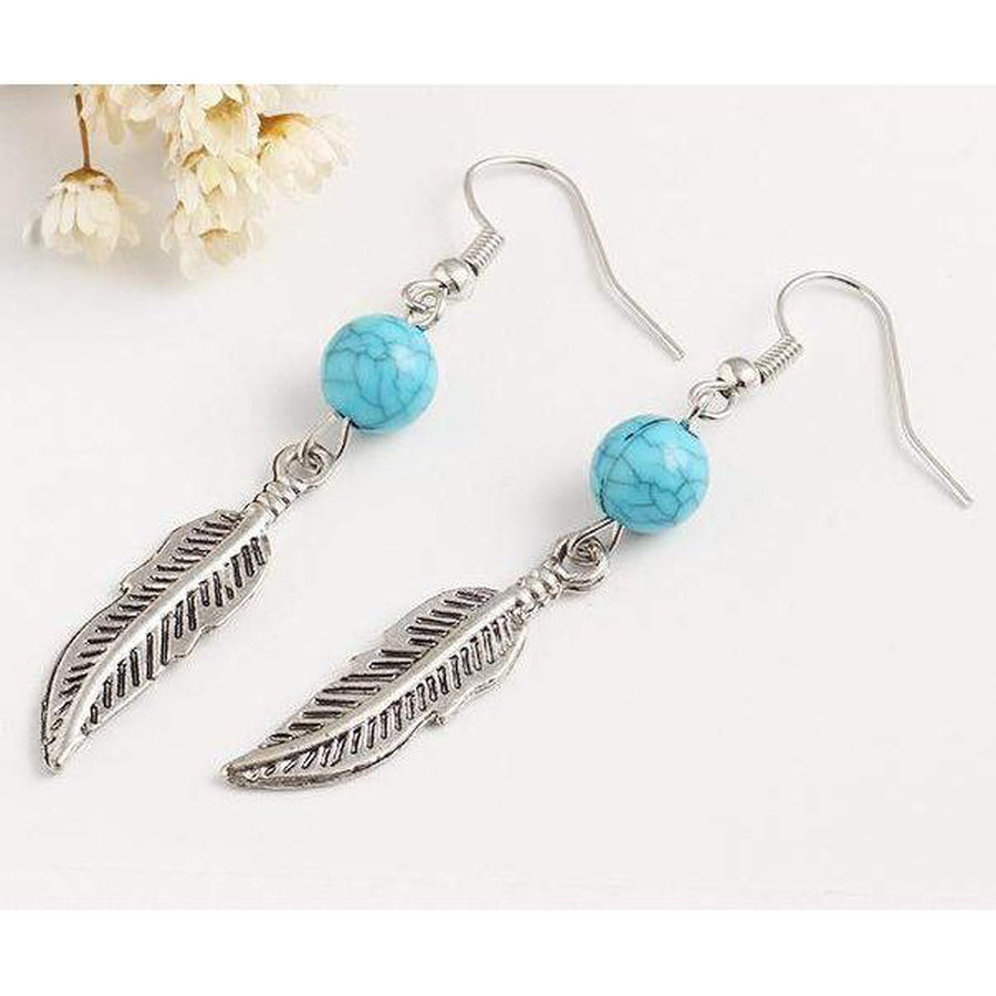 Boucles pendantes bohèmes avec plume et perle turquoise