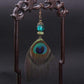 Vue latérale de boucles d'oreilles plumes de paon élégantes