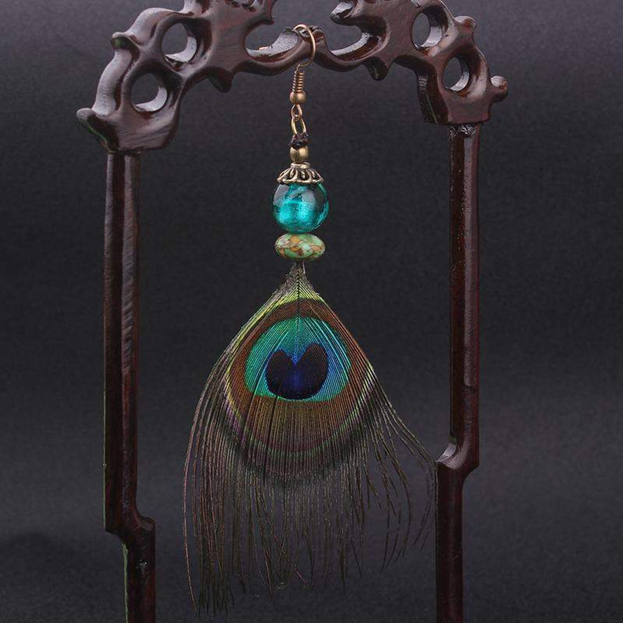 Vue latérale de boucles d'oreilles plumes de paon élégantes