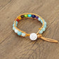 Bracelet en perles colorées sur cordon en cuir avec arbre de vie