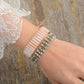 Vue latérale du bracelet, bouton de fermeture gravé visible