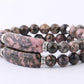 Gros plan sur les perles de rhodonite, texture lisse et brillante