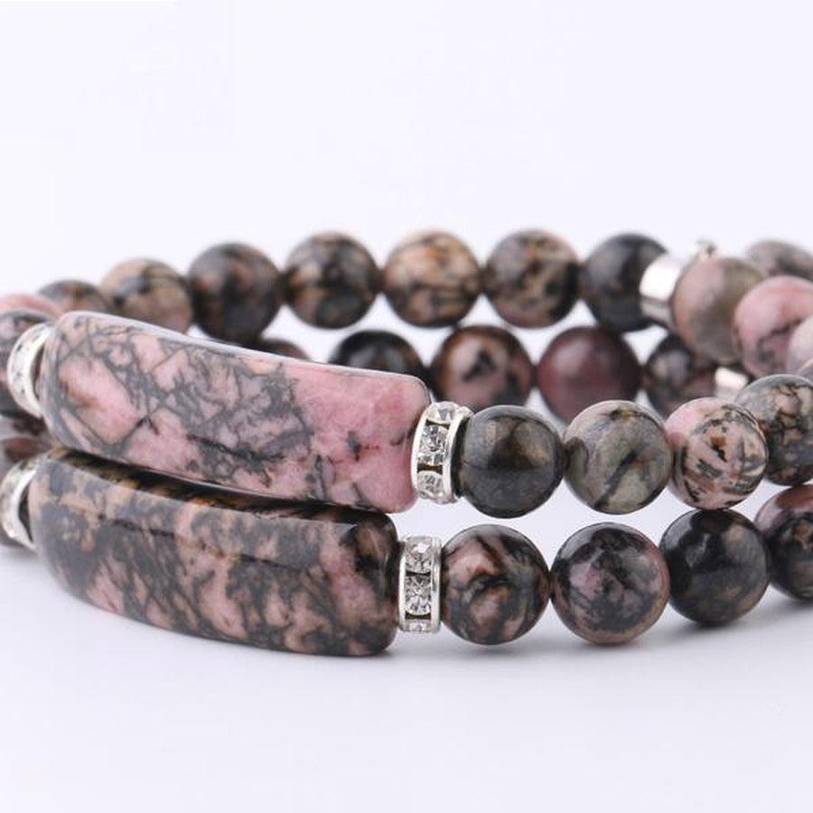 Gros plan sur les perles de rhodonite, texture lisse et brillante