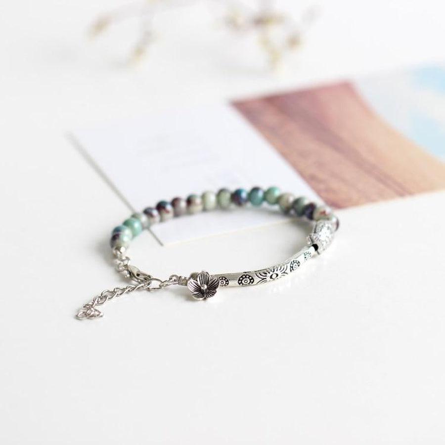 Détail du pendentif en forme de fleur sur le bracelet