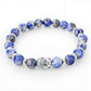 Vue rapprochée du bracelet en pierres bleues marbrées et Bouddha