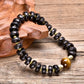Bracelet bouddhiste montrant le motif Om sur perles coco