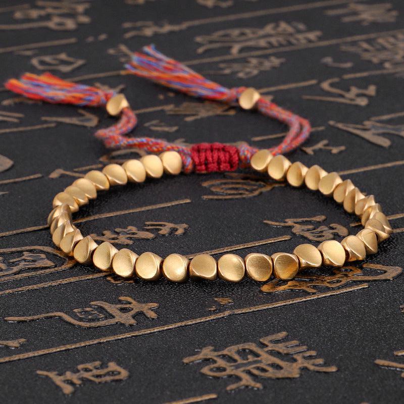 Bracelet bouddhiste posé sur une surface en bois