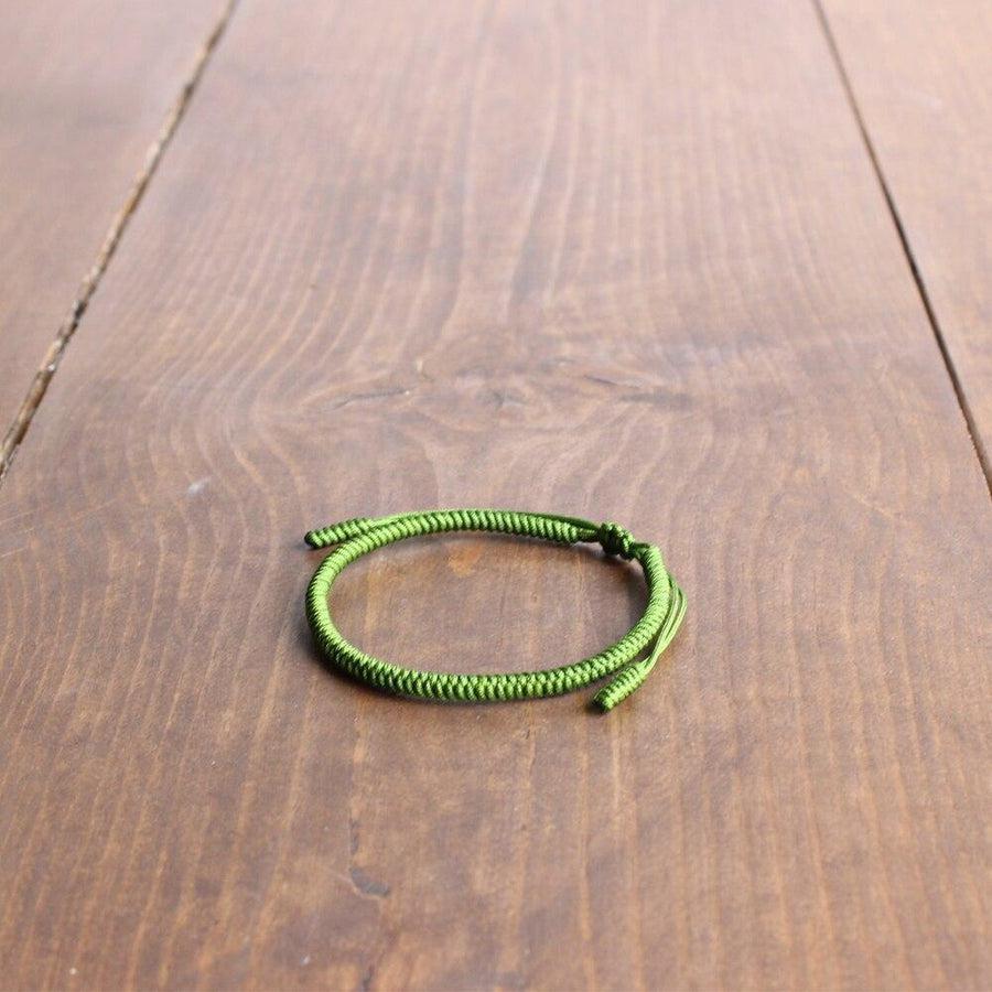 Bracelet rouge enfilé sur un poignet, vue latérale