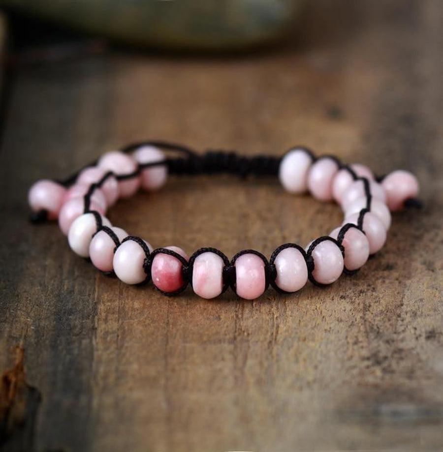 Bracelet artisanal en opale rose, posé sur une surface claire