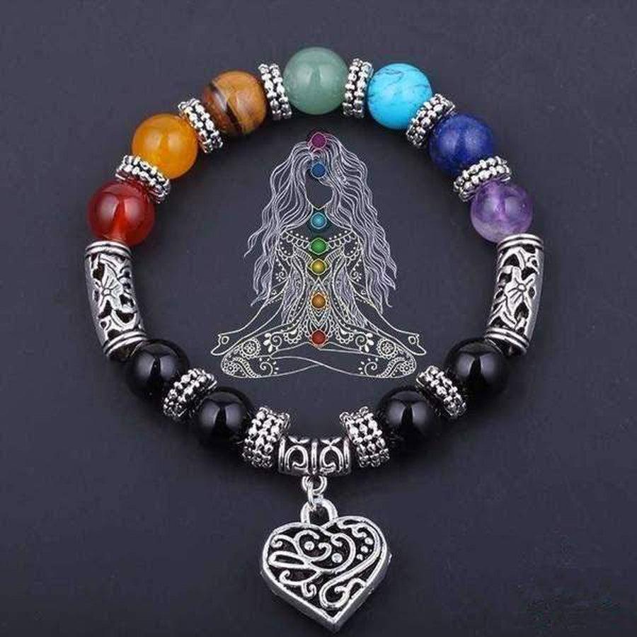 Bracelet de pierres chakras posé sur une surface en bois