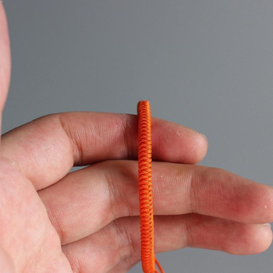 Vue rapprochée du bracelet bouddhiste avec texture de corde