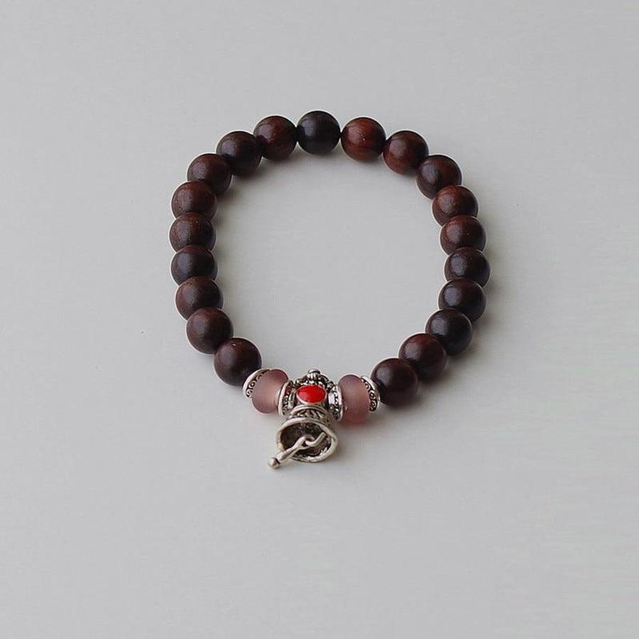 Bracelet en bois avec perles brun foncé et cloche